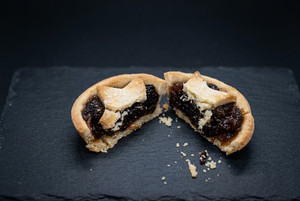 A star-topped mince pie cut in half to show the mincemeat inside the shortcrust case